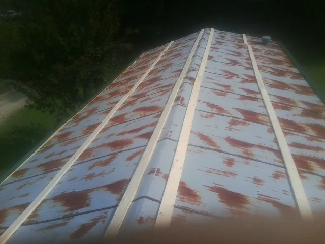 Rusted metal roof panels with new wood purlins before replacement — Storm Damage Roof Repair in Lewis Center by Roofing Brothers