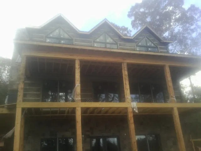 Dormers and porch framing on a large log home under construction — Roof Coating work by our crew in Lewis Center