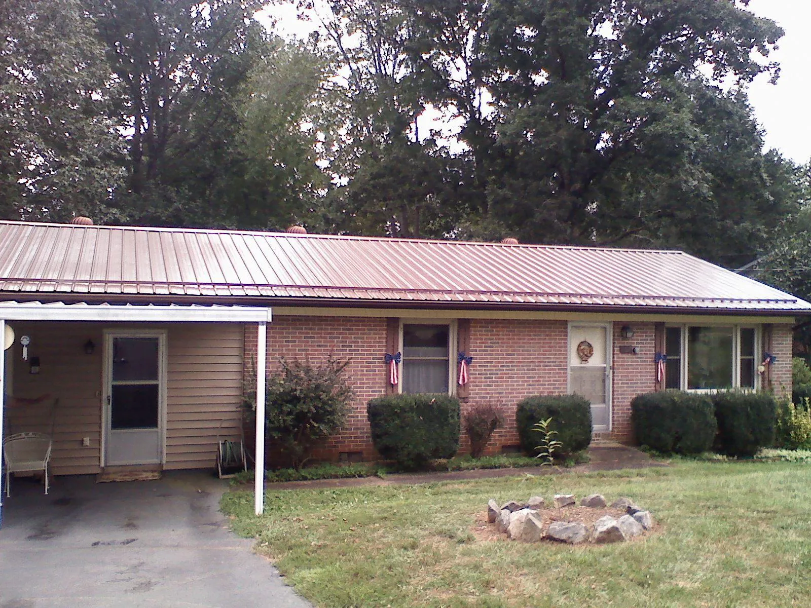 Bronze metal roof and carport on a brick ranch home — Roof Repair work by our crew in Lewis Center